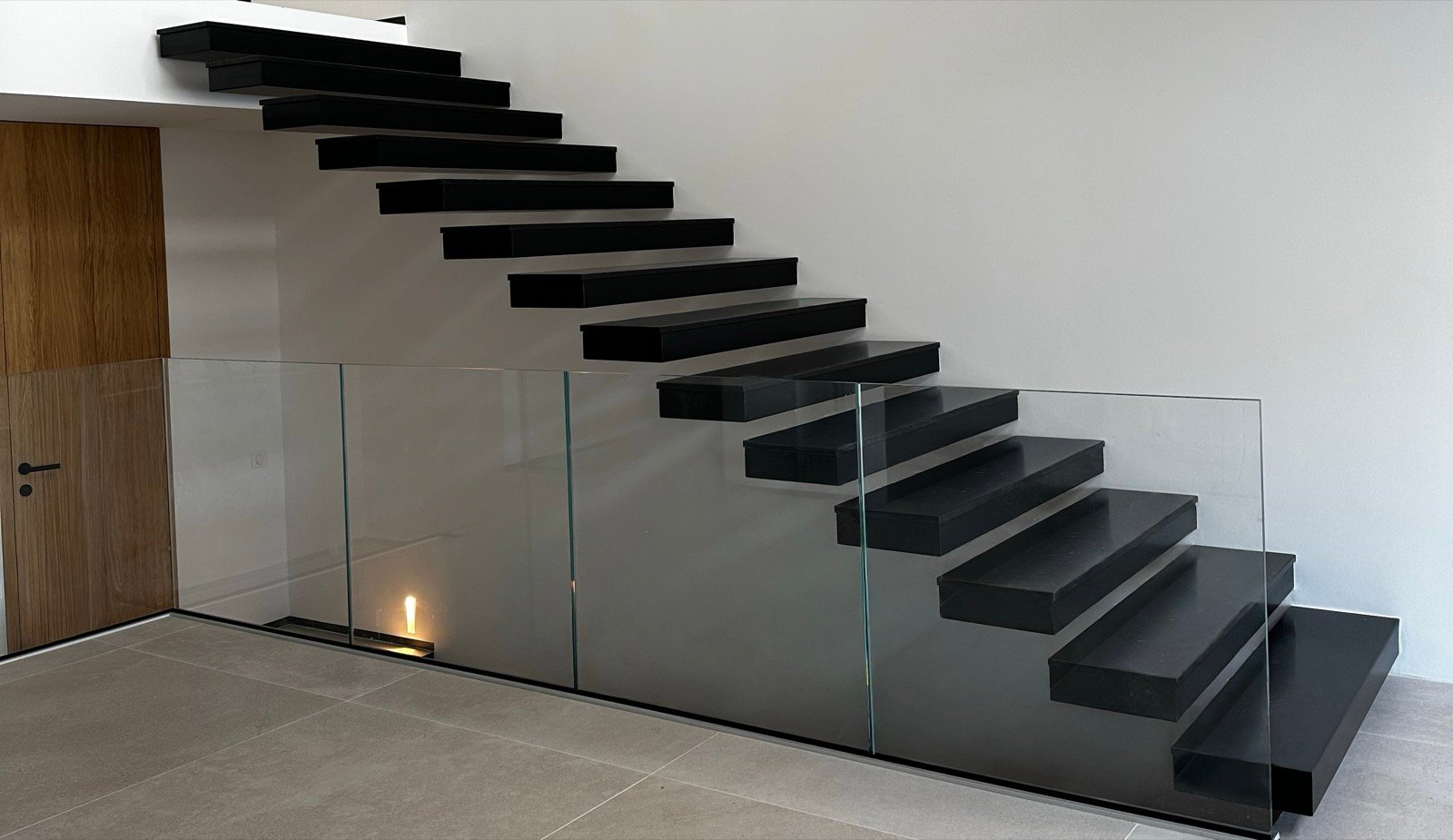 Escalier suspendu métallique noir et garde-corps en verre