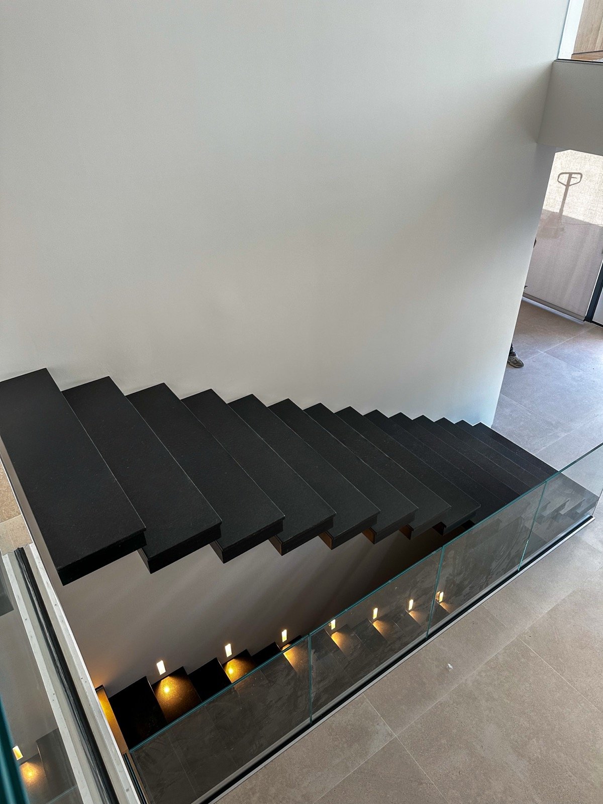 Escalier suspendu métallique noir et garde-corps en verre