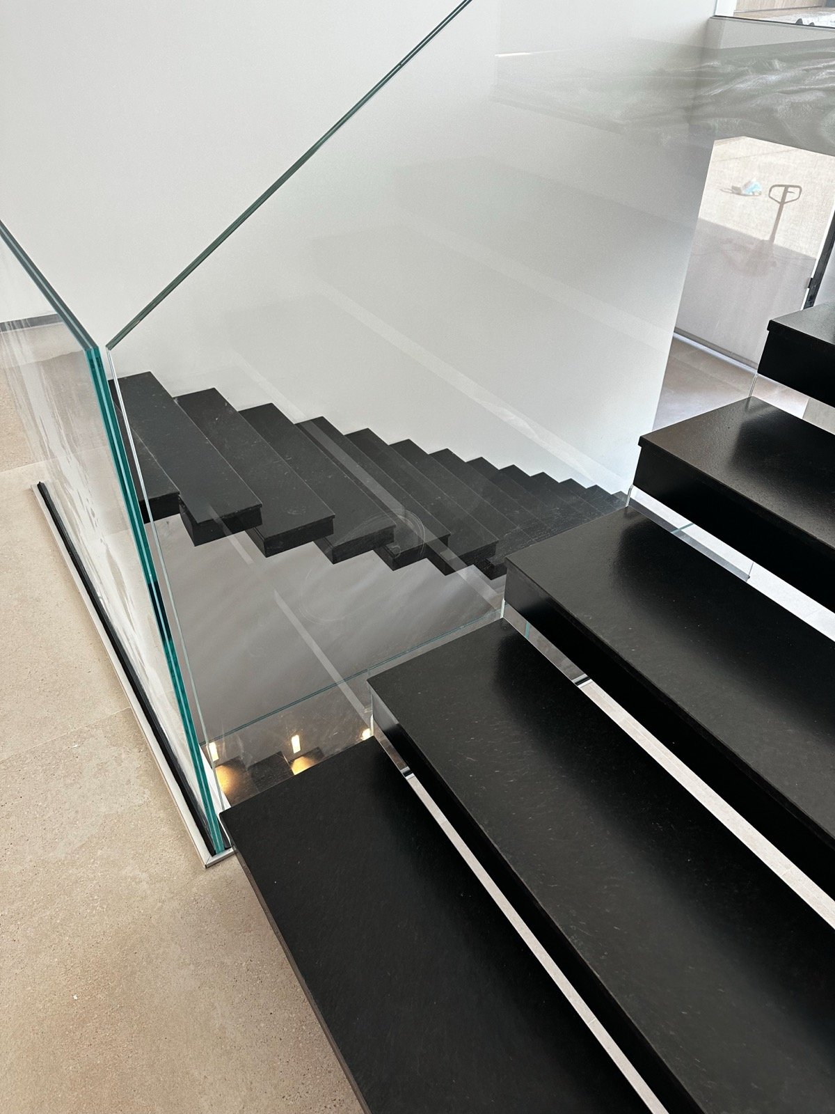 Escalier suspendu métallique noir et garde-corps en verre