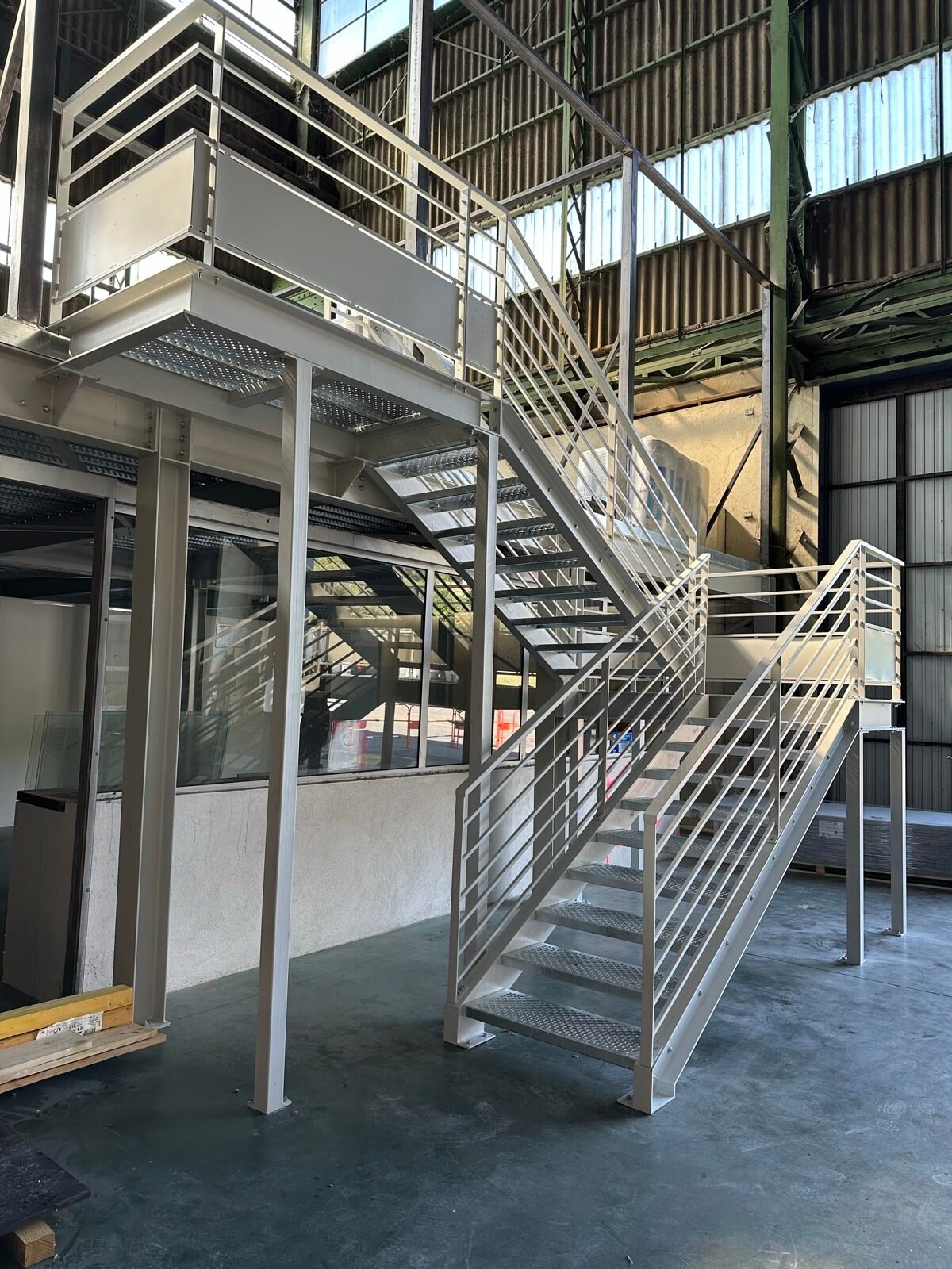 Structure et plancher collaborant pour une mezzanine de bureau avec escalier métallique
