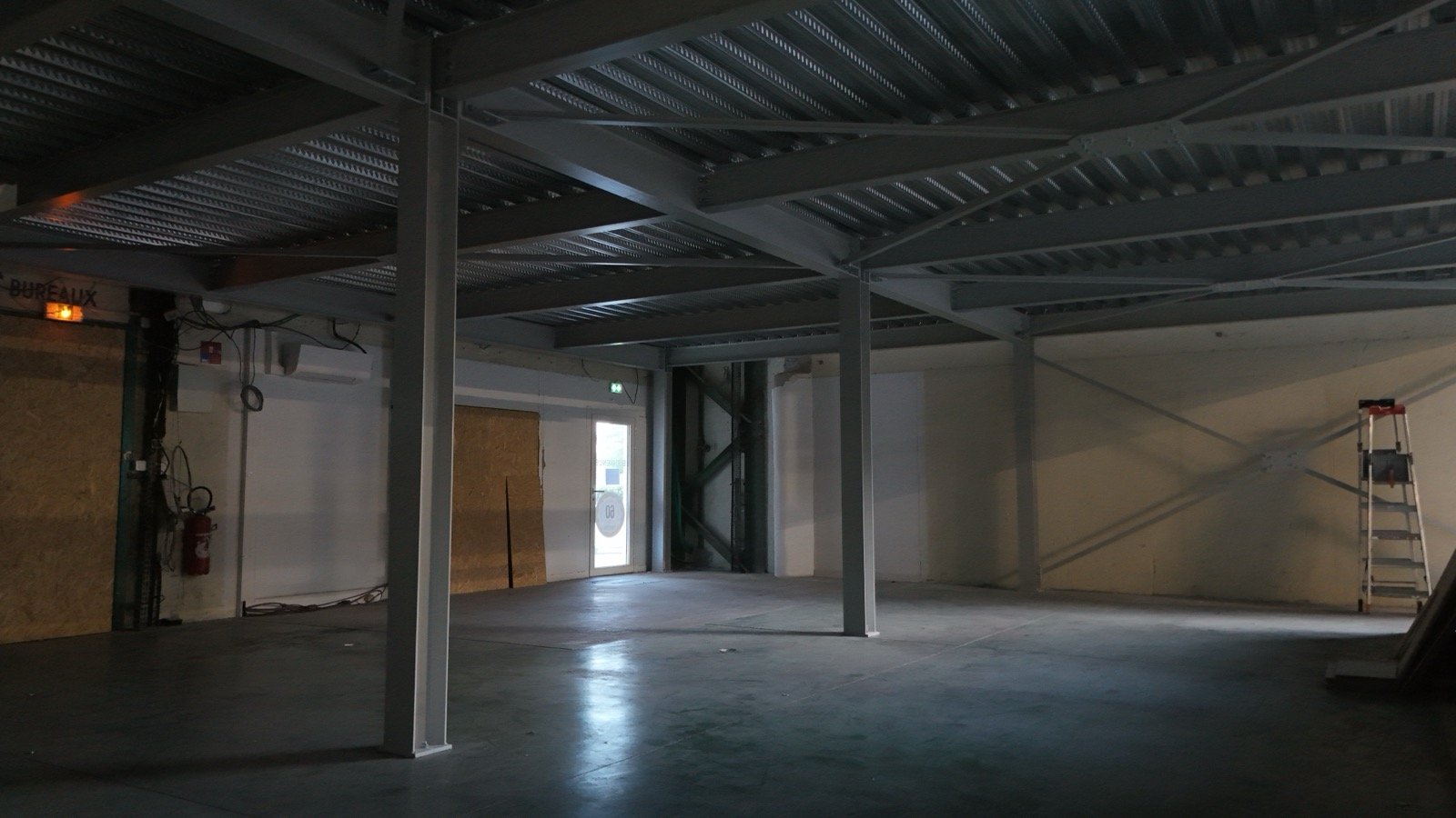 Structure et plancher collaborant pour une mezzanine de bureau avec escalier métallique